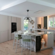 Cuisine ouverte sur mesure avec îlot central en quartzite Alpinus, façades cachemire et détails en bois clair. - photo 1